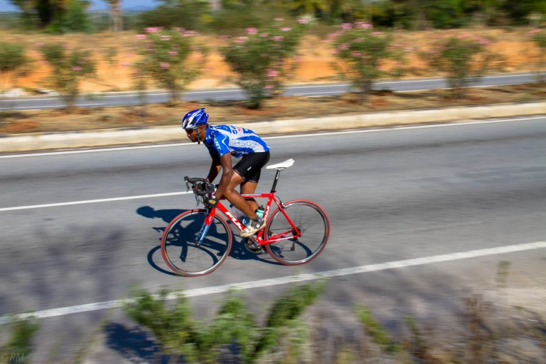 a bicyclist wearing a helmet rides down the road