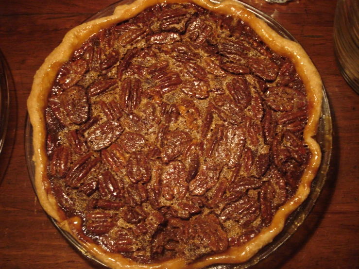 a pie topped with nuts sitting on top of a wooden table