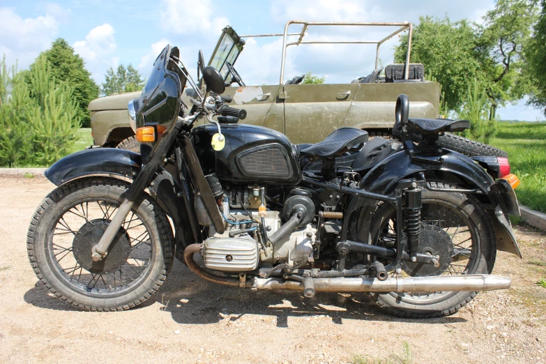 two black motorcycles sitting in front of an army vehicle