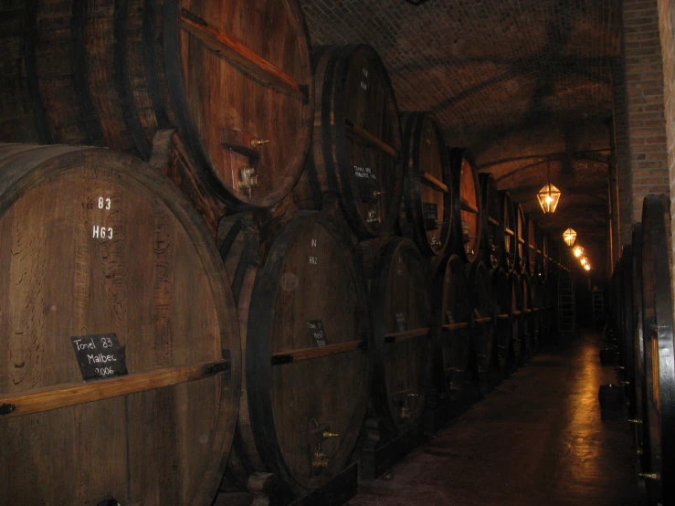 a row of wine barrels in an old wine cellar