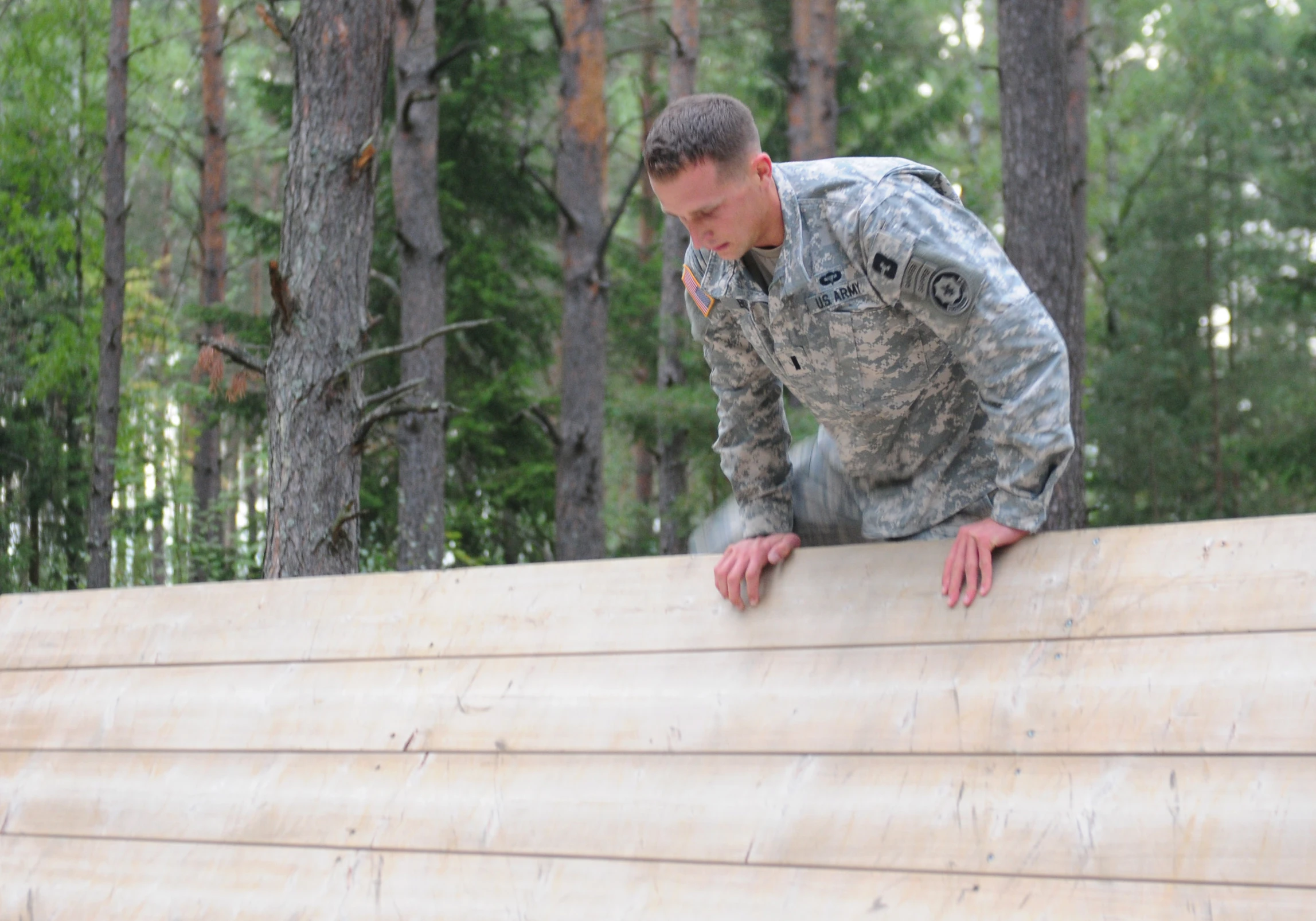 a man in military camouflage looks down from the edge of the platform