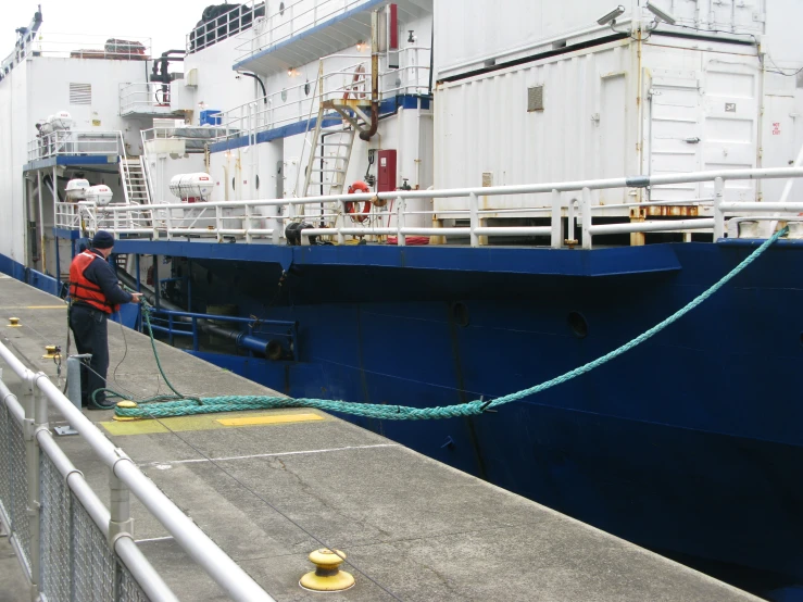 a man is standing on a boat loading the rope