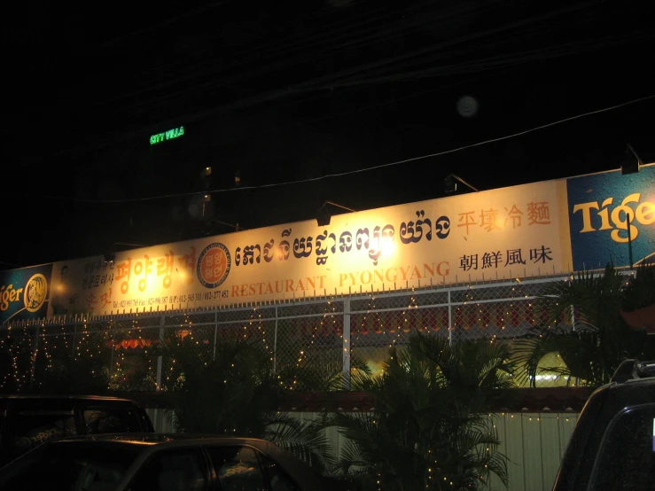 the lighted sign in front of the building is advertising a restaurant