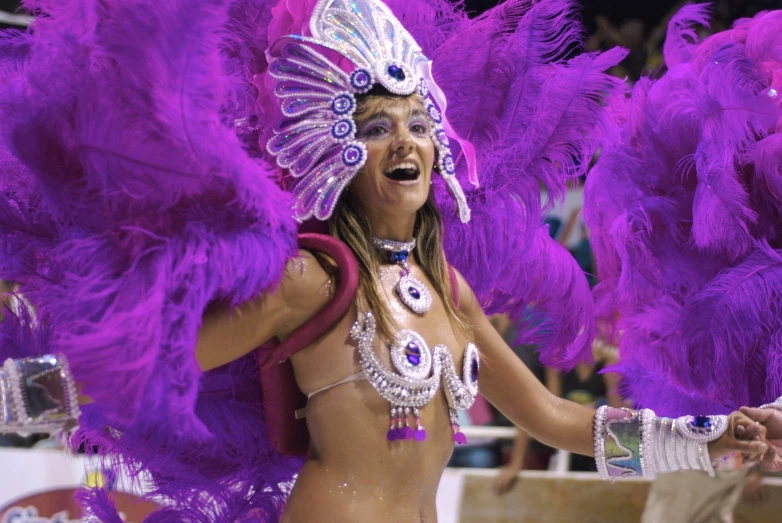 a belly dancer with a purple costume and bright feathers