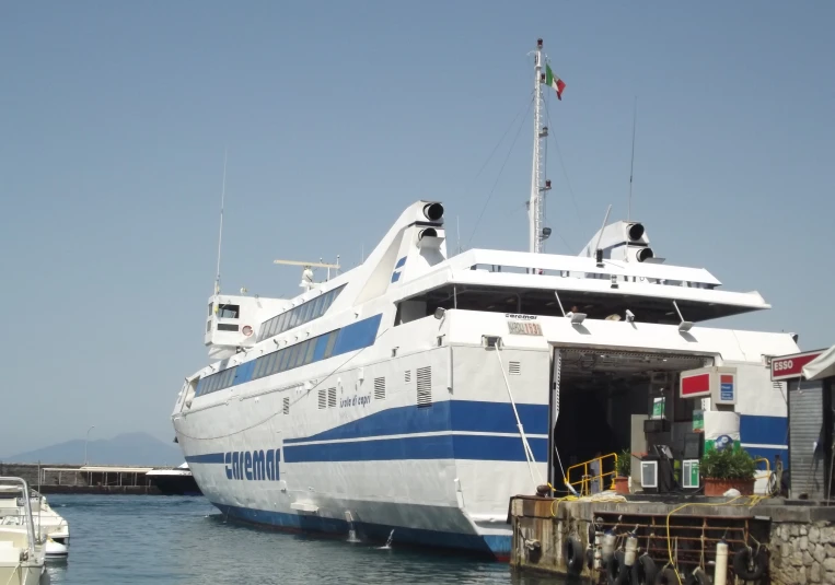 a white boat with blue stripes parked at the dock