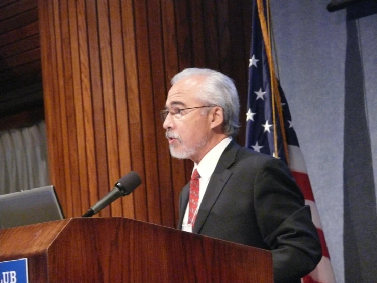 a man standing at a podium in front of a microphone