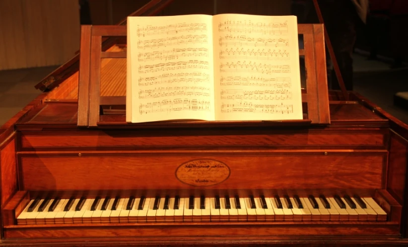 an open book on a piano by a sheet of music