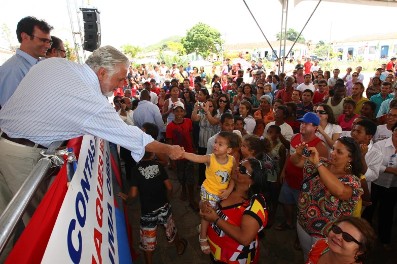 a young child is being handed a flag by an older man