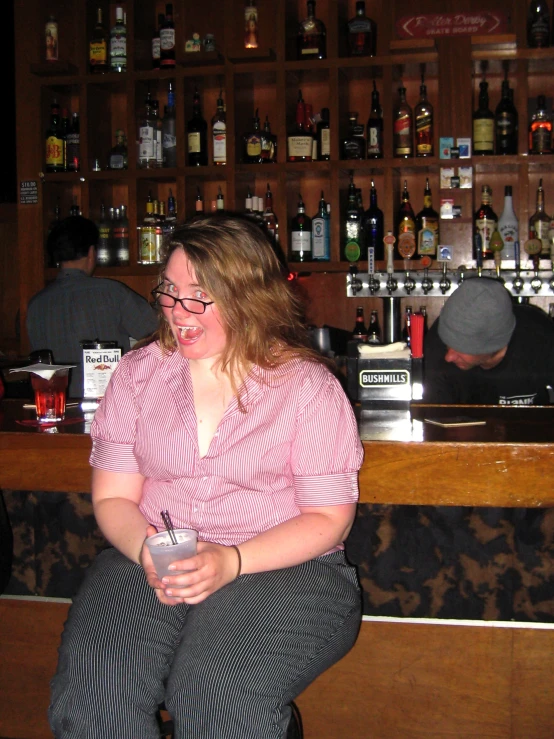 a woman is sitting at a bar smiling