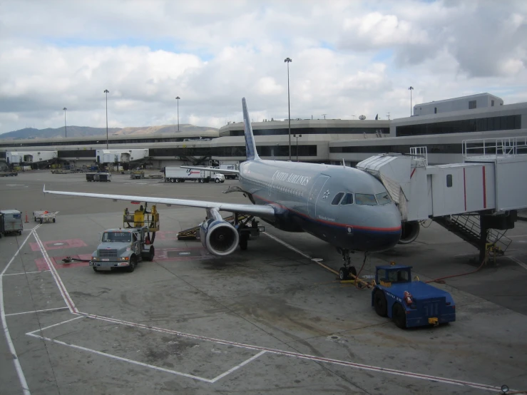 the airplane is parked in the concrete lot by a building