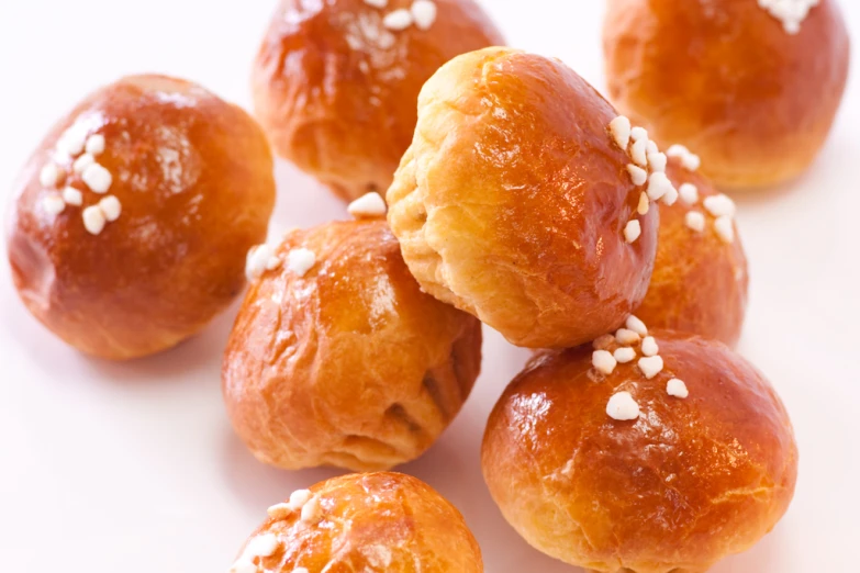 four puffy doughnuts are sitting on a white surface