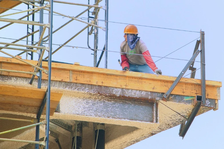 a worker wearing a safety helmet and safety gear is building a new bridge