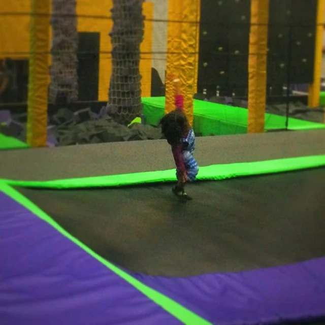 a small child rides on a skateboard in an indoor playground