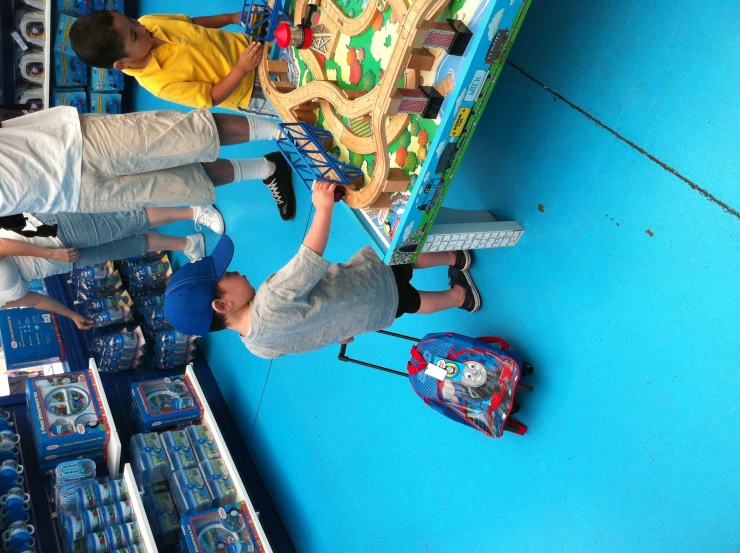 two boys are playing with a train set