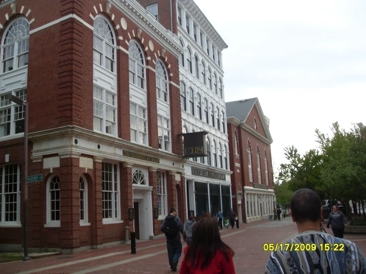 people walking in front of a brick building