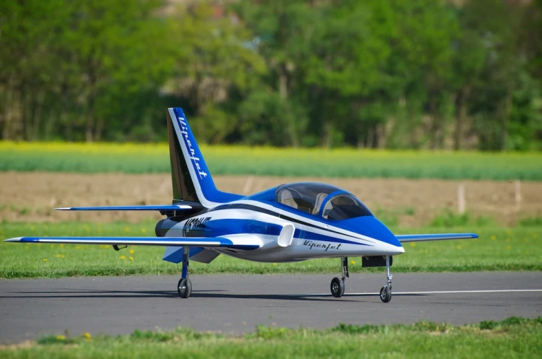 a small blue and white airplane taking off from an airport runway