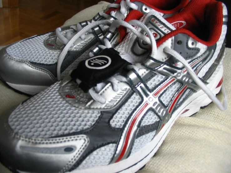 a pair of white and red running shoes with the shoe laces down