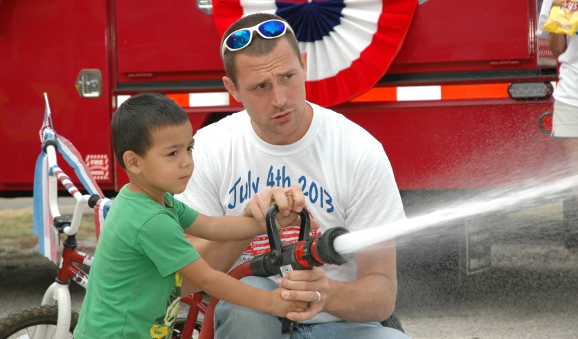 a man is giving a boy a water cannon