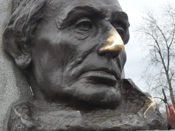 a close up of a statue with trees behind it