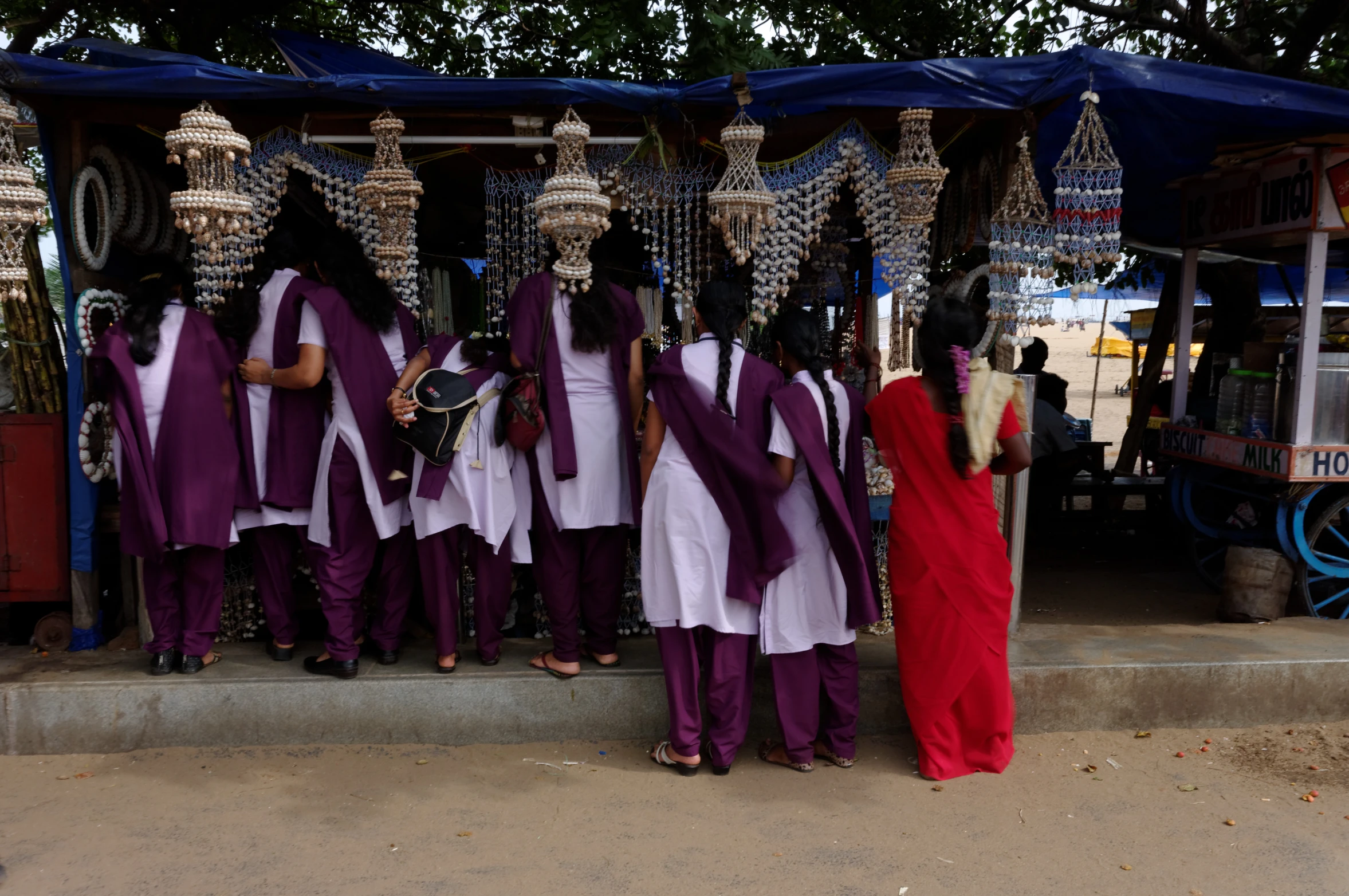 women dressed in white and purple are looking at items