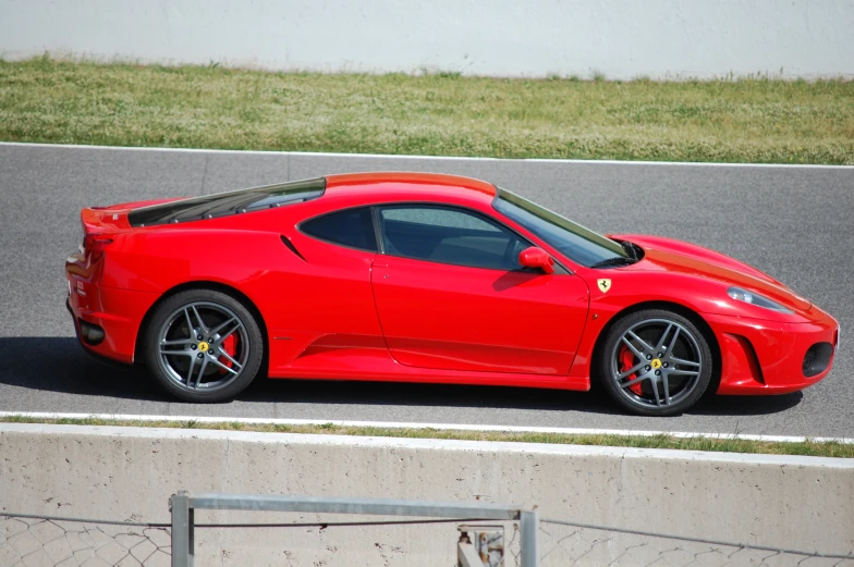 a red sports car sitting on the side of the road