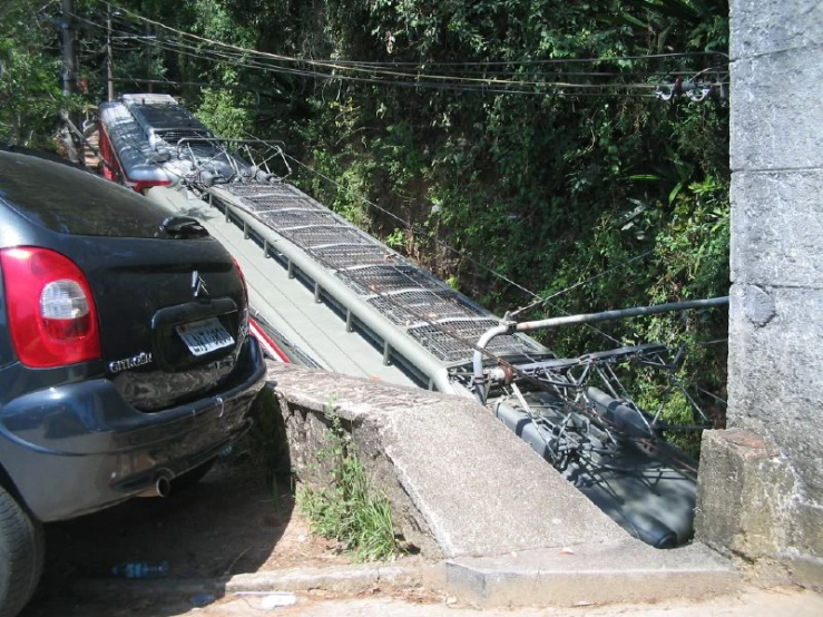 several cars on the side of a bridge with bicycles strapped on it