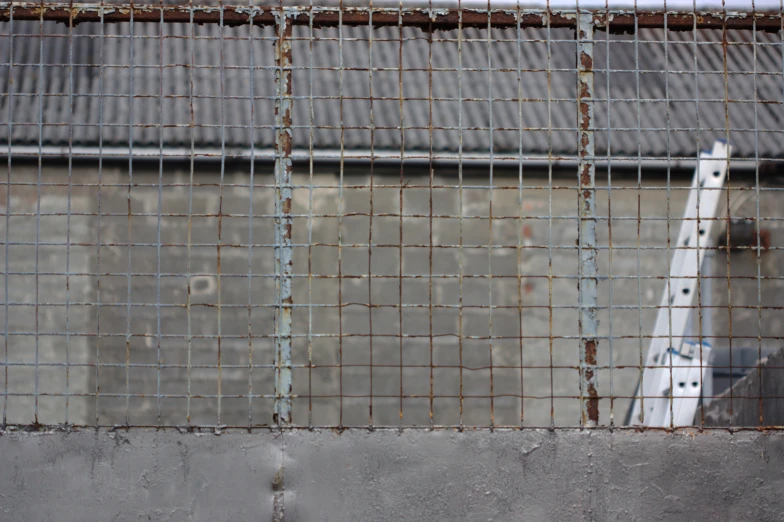 a baseball bat sits behind the fence behind a building