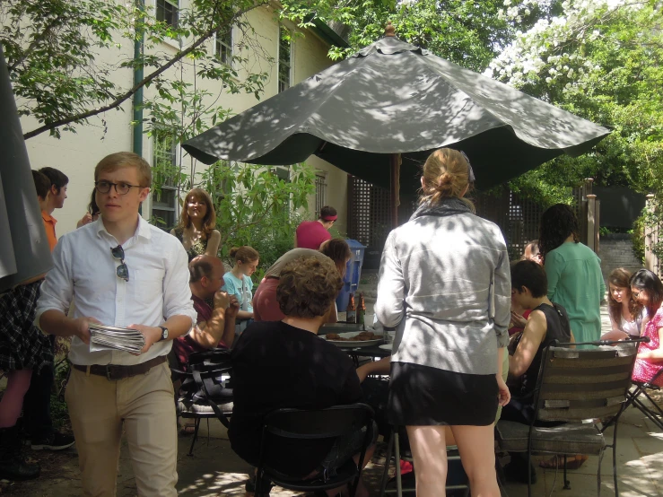 a man and woman talking in a crowded area with chairs and tables