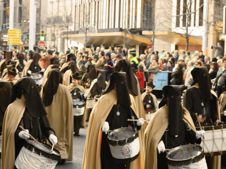 several people dressed in strange costumes walking down the street