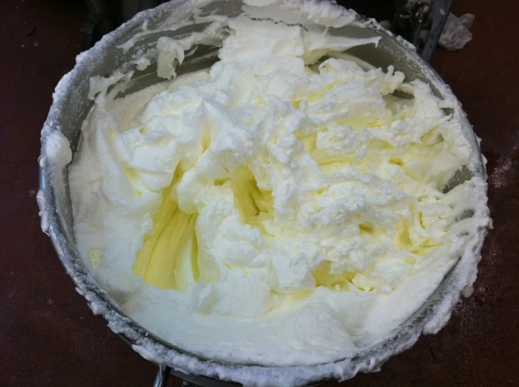 a bowl full of whipped cream sits on a table