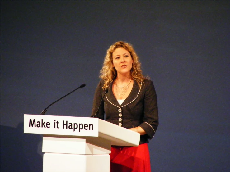 the woman is speaking at the event on the microphone