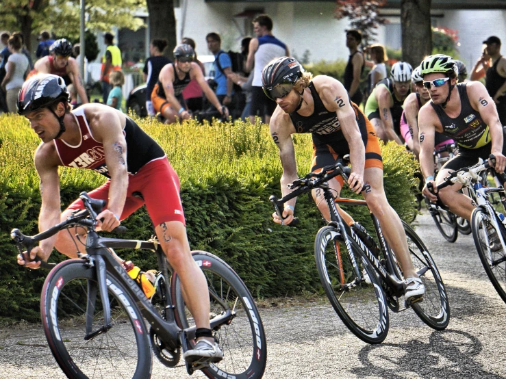 a group of cyclists riding down the road near each other