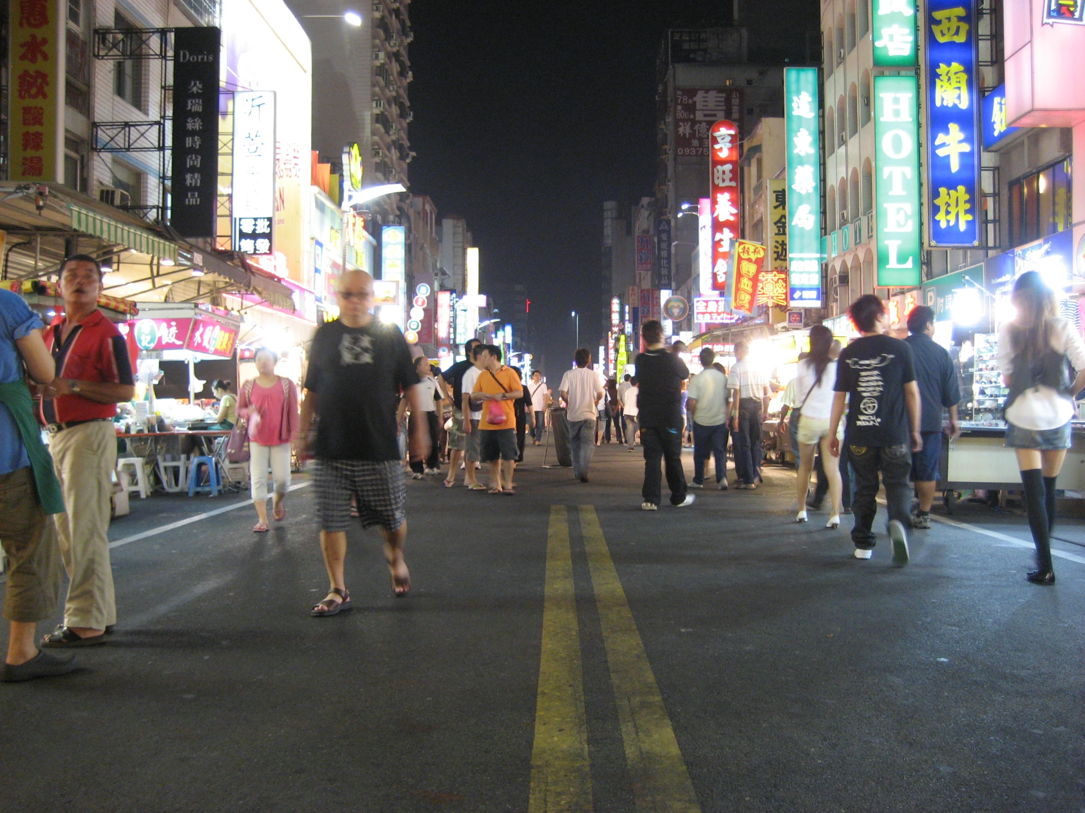 an asian city street at night filled with people