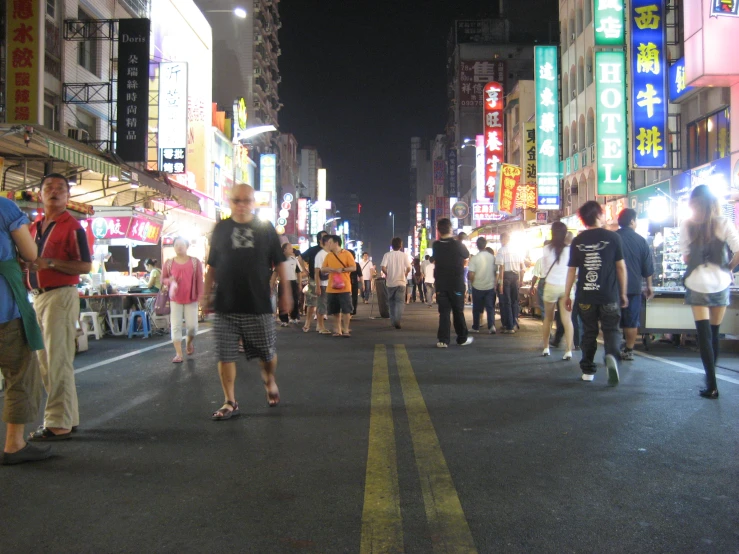 an asian city street at night filled with people