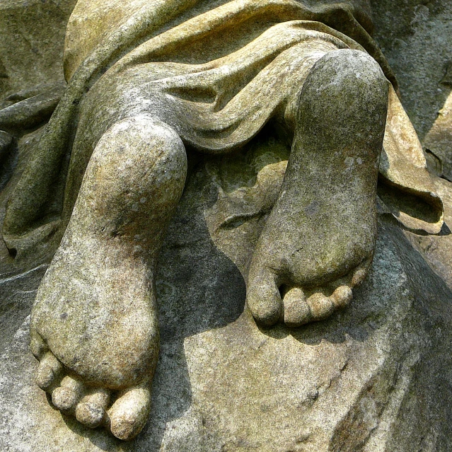 a stone statue of an animal with a blanket around it's feet