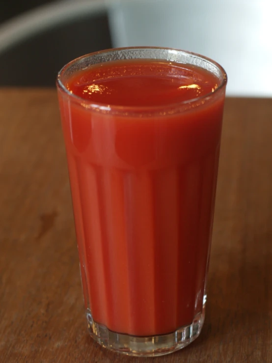 a small glass filled with ketchup on top of a table