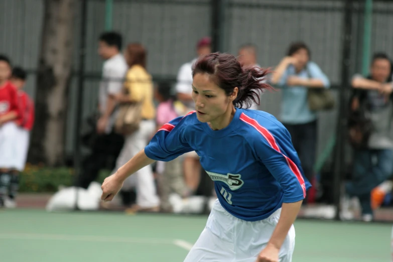 a young woman playing tennis with many people watching