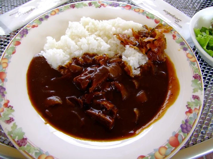 a bowl of rice and a side dish with some meat