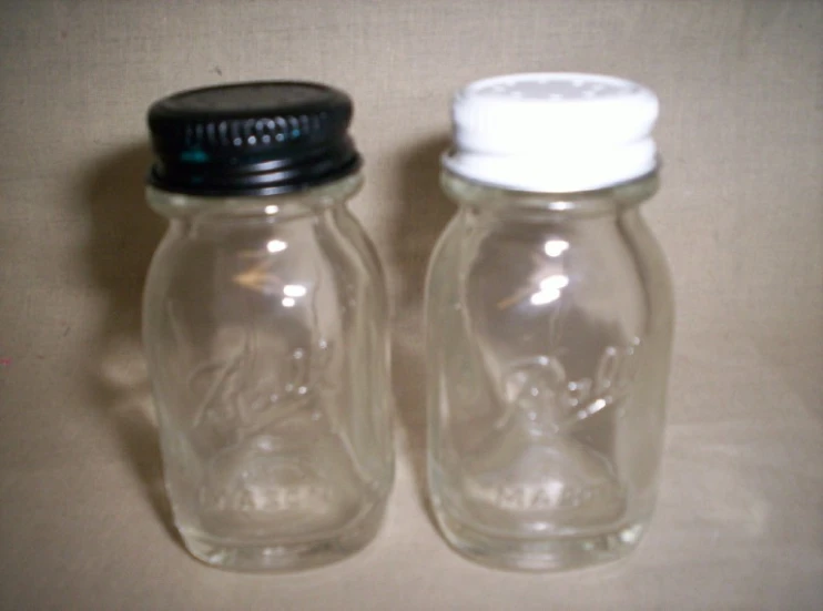 two large clear jars on top of a table