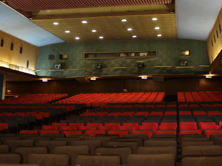 an auditorium with rows of empty seats with the lights on