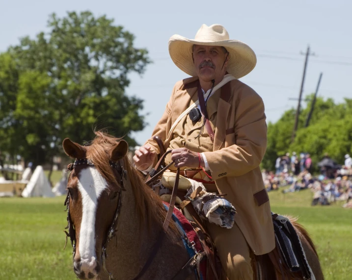 a man is riding a horse with spectators in the background