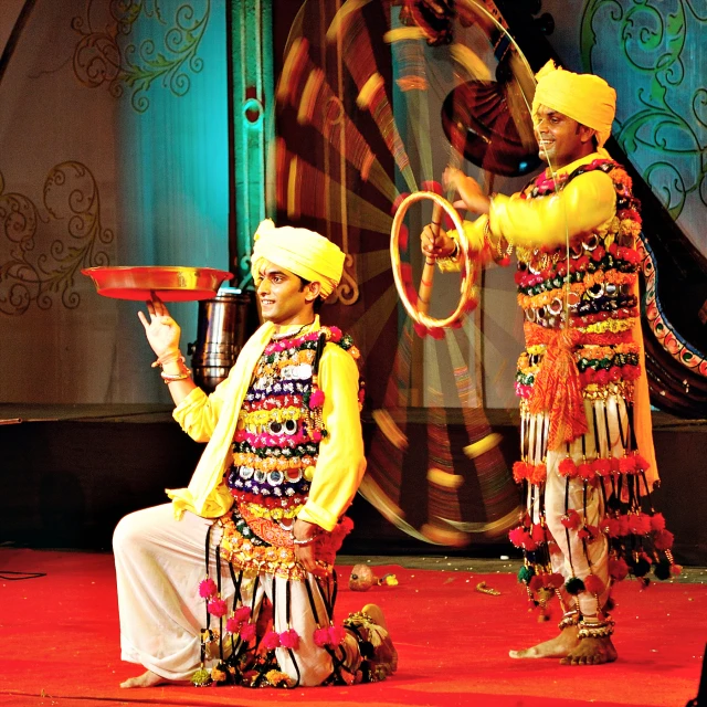 two men in elaborate costumes stand on a stage
