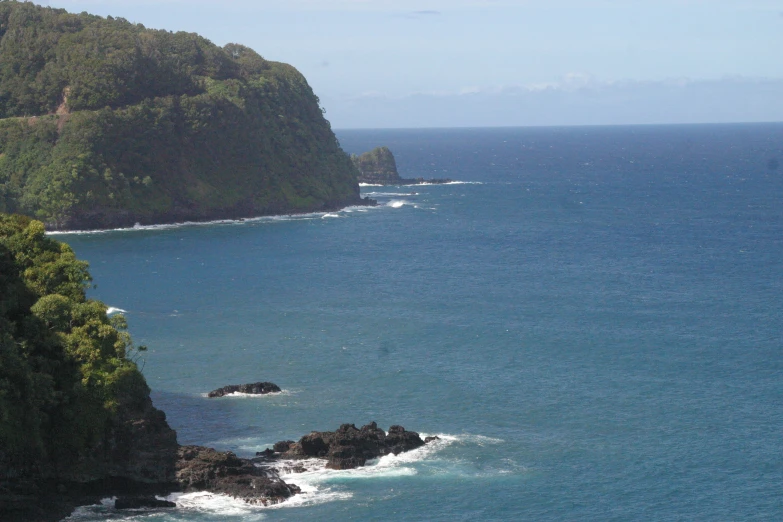 a view of the ocean from a cliff with water in the foreground