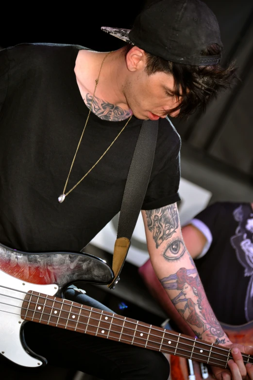 a man with tattoos holding onto a guitar