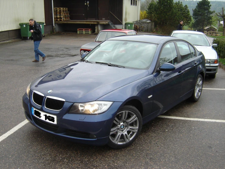 a blue bmw is parked in a parking lot