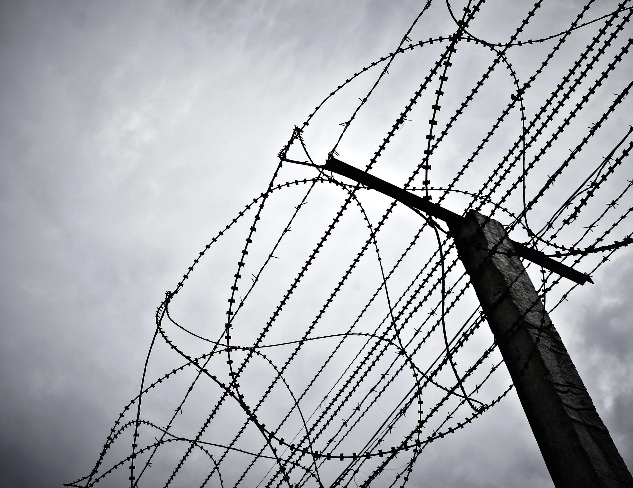 a barbed wire post and a sky in the background