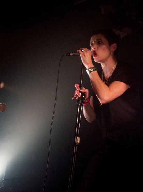 a man standing at a microphone with his hand in the air