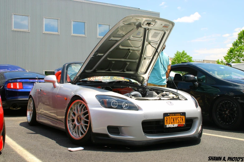 the sports car is parked with its hood open