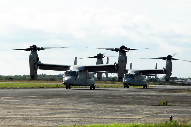 several airplanes sit on a runway next to each other