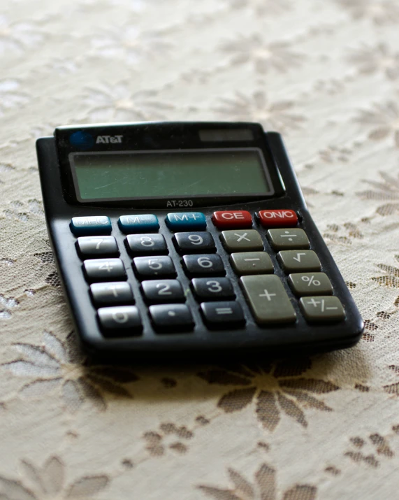 the calculator is resting on the lace table cloth